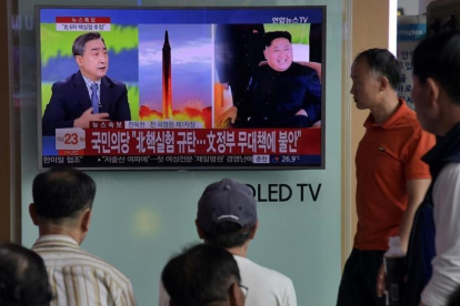 Ciudadanos surcoreanos siguen la noticia del ensayo nuclear de Corea del Norte en una estación de Seúl.-AFP / ED JONES