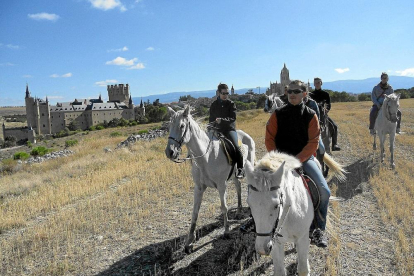 Turistas pasean a caballo en Segovia.-ICAL