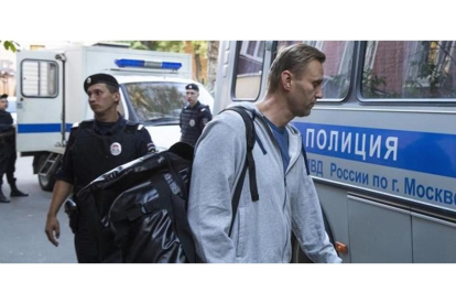 Navalny abandona el tribunal donde fue condenado hacia la prisión rodeado de agentes policiales. /-PAVEL GOLOVKIN / AP
