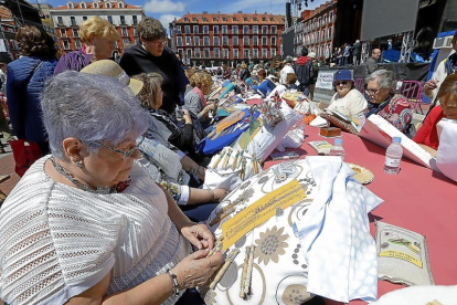 Varias mujeres entretejen sus encajes de bolillos, ayer en la Plaza Mayor durante el II encuentro celebrado con motivo de las fiestas patronales.-J.M. LOSTAU