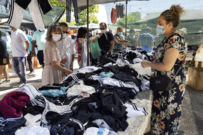 Una comerciante vende ropa en su puesto del mercadillo del real de la feria.- REPORTAJE GRÁFICO DE PHOTOGENIC/PABLO REQUEJO