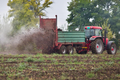Un agricultor realiza trabajos agrícolas con maquinaria sobre un campo recién abonado.-ECB
