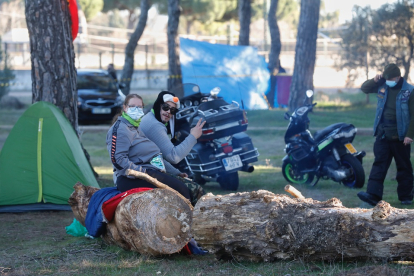Moteros descansan en la acampada encima de los enormes troncos. PHOTOGENIC