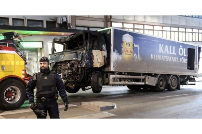 La policía retira, este viernes por la noche, el camión con el que un terrorista perpetró un atentado en el centro de Estocolmo.-EFE / MAJA SUSLIN