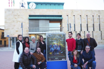 El equipo de organización del calendario posa junto al cartel de presentación en la Plaza Mayor de Pedrajas. EUROPA PRESS