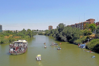 El ‘Leyenda del Pisuerga’ acompaña ayer a un grupo de embarcaciones participantes en la procesión fluvial.-ICAL