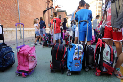 Varios alumnos apilan mochilas en la entrada del colegio.-ICAL