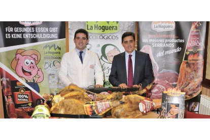 Teo y Carlos Martínez posan ante parte de la gama de productos de La Hoguera en sus instalaciones de 17.000 metros cuadrados de San Pedro Manrique.-VALENTÍN GUISANDE