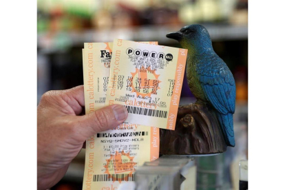 Un hombre muestra sus billetes de lotería Powerball en la tienda de licor Bluebird el 22 de agosto de 2017, en Hawthorne, California (EE.UU.).-EFE