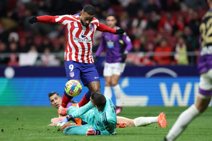 Memphis Depay en su debut con el Atlético intenta picar el balón ante la salida de Masip./ AFP