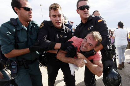 Un manifestante con una herida en la frente es agarrado por miembros de la Guardia Civil y la Policía Nacional-