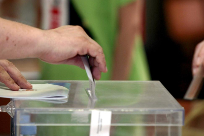 El presidente de una mesa electoral de Valladolid introduce en la urna el voto de un ciudadano.-ICAL