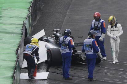 Lewis Hamilton, al lado de su Mercedes siniestrado.-AP / NELSON ANTOINE
