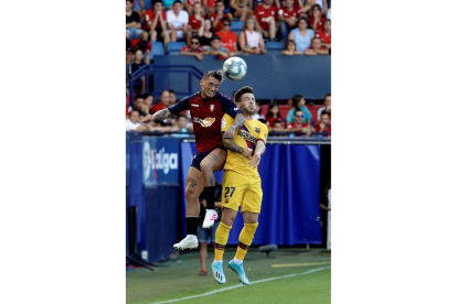 El delantero argentino de Osasuna Chimy Ávila (i) disputa un balón con Carles Pérez, del FC Barcelona, en el partido correspondiente a la 3ª Jornada de LaLiga Santander que Osasuna y FC Barcelona disputan hoy sábado en el estadio El Sadar, en Pamplona.-EFE
