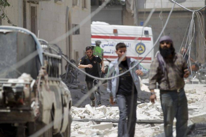 Un grupo de civiles junto al lugar donde ha estallado un barril lanzado por el régimen sirio.-Foto: REUTERS / KHALIL ASHAWI