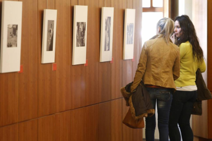 Dos personas observan las imágenes de la exposición `150 años de Acción Humanitaria con las Víctimas de la Guerra'-Ical