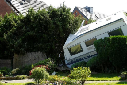 Una caravana derribada sobre un jardín tras el paso del tornado en el área de Boisheim, en el oeste de Alemania, este miércoles.-/ THILO SCHMUELGEN (REUTERS)