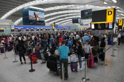 Colas de pasajeros originadas por el fallo informático, en la terminal 5 del aeropuerto inglés de Heathrow, ayer.-AFP / DANIEL LEAL-OLIVAS