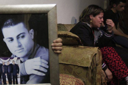 La madre del presunto espía asesinado por el EI llora junto a un retrato de éste en su casa en Jerusalén.-Foto: EFE / STR