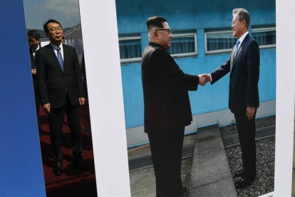 Un alto funcionario surcoreano observa una foto del presidente de Corea del Sur, Moon Jae-in, y del de Corea del Norte, Kim Jong-un, expuesta en Pyongyang.-AFP