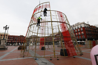 Operarios instalan la base del árbol de Navidad en la Plaza Mayor. -J.M. LOSTAU