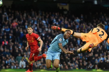 Sterling, del manchester City, choca con el portero del Liverpool Mignolet.-AFP