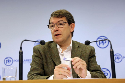 Fernández Mañueco sujeta un pendrive en el que está el programa electoral de mayo presentado ayer.-ICAL