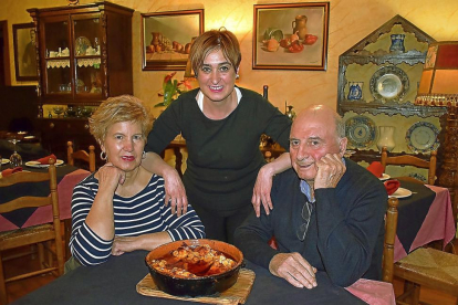 Nuria, con sus padres Zoilo y Julia, y el bacalao al ajoarriero que ha hecho célebre su restaurante.-ARGI