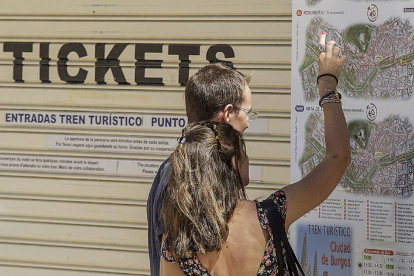 Dos turistas observan un plano del tren turístico de Burgos.-Santi Otero