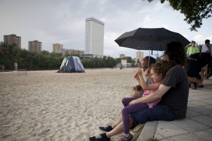 Una familia se tapa con un paraguas en Moreras.-José C. Castillo