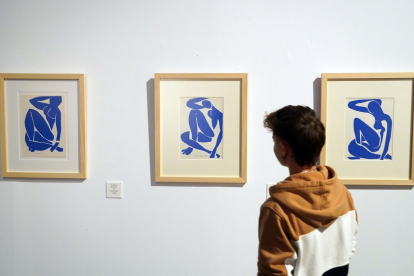 Un joven contempla litografías de los collages de la serie ‘Desnudo azul’. | ICAL