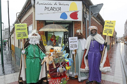 Los Reyes Magos piden con pancartas la reapertura del paso a nivel en el barrio de Pilarica.-J.M. Lostau