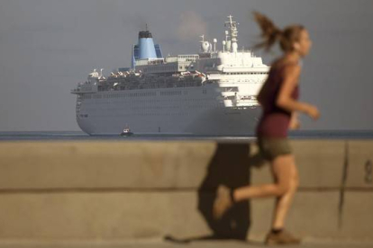 Una mujer corre por el Malecón mientras el crucero Thomson Dream llega a La Habana, el 19 de marzo.-Foto:   AP / DESMOND BOYLAN