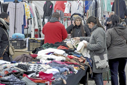 Una cliente observa diversas prendas de vestir en uno de los puestos instalados en el mercadillo medinense-Santiago G. del Campo