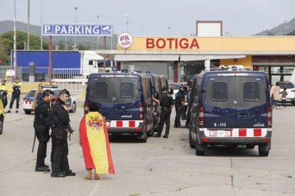 Una mujer con la bandera española habla con los Mossos, en la frontera con la Junquera.-JOAN CASTRO / ICONNA