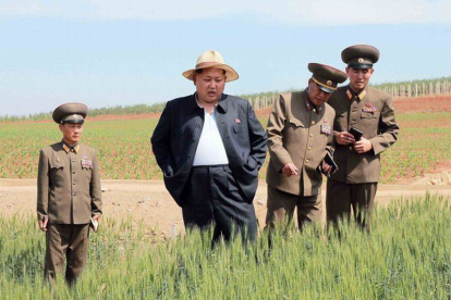 Kim Jong-un en una inusual imagen con su chaqueta abierta durante la visita a una granja.-Foto: KNS / AFP