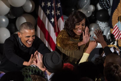 Obama y su mujer, Michelle, saludan a un grupo de niños en un evento por Halloween en la Casa Blanca, en Washington.-AFP / NICHOLAS KAMM