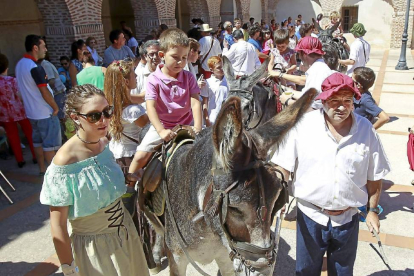 Un niño disfruta de un paseo en burro en el recinto donde estaban ubicados diferentes expositores que recreaban oficios barrocos.-J. M. Lostau