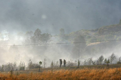 Vecinos de la localidad de San Pedro Mallo, perteneciente al municipio de Toreno (León), contemplan el trabajo de los equipos de extinción de incendios