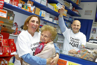 Leonor se entera en el establecimiento de que su décimo tiene premio, en compañía de los hermanos Pilar y Juan Carlos Arribas.-J. M. LOSTAU