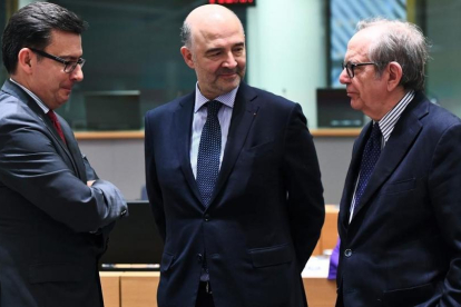 El ministro de Economía italiano, Pier Carlo Padoan (derecha), su homólogo español, Román Escolano (izq) y el comisario europeo Pierre Moscovici, antes de la reunión del Eurogrupo, el 12 de marzo.-/ AFP / EMMANUEL DUNAND