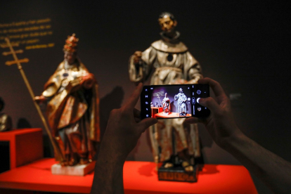 Una persona fotografía dos piezas de la muestra 'Extraña devoción, en Villena. | LOSTAU