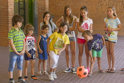 Los niños que participan en el proyecto 'Compartiendo en verano' juegan en el patio con una de las actividades antes de la comida.-Pablo Requejo