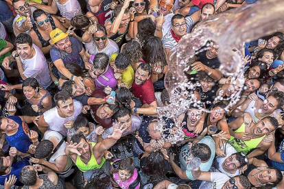 Una multitud de peñistas recibe un baño de agua durante la celebración del chúndara en Peñafiel.-J.M. LOSTAU