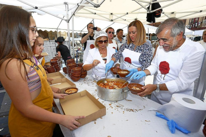 La delegada del Gobierno, Virginia Barcones, sirviendo unos platos de alubias junto a los organizadores, ayer en La Bañeza.-E. M.