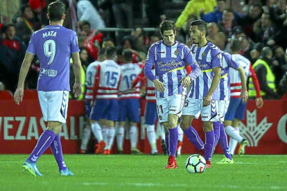 Los jugadores del Granada celebran el gol, al fondo, ante la decepción de Mata, Hervías y Anuar, anoche en Los Cármenes.-PHOTO-DEPORTE