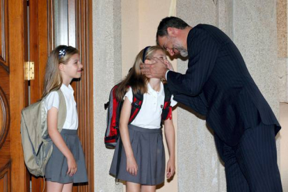 El rey Felipe besa a sus hijas Leonor, Princesa de Asturias, y Sofía, al término de la jornada escolar, tras regresar de la entrega del premio Carlomagno, en Aquisgrán, el 14 de marzo del 2015. © CASA DE S.M. EL REY