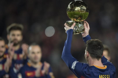 Leo Messi levanta el Balón de Oro del 2015 en el Camp Nou, en enero pasado.-JORDI COTRINA