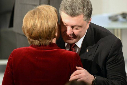 La cancillera Angela Merkel y el presidente de Ucrania, Petro Poroshenko, se saludan en Múnich.-Foto: THOMAS KIENZLE / AFP