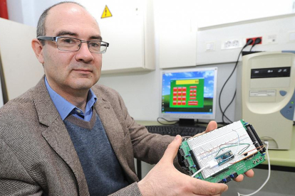 José María Cámara enseña el dispositivo, formado por un microcontrolador y un receptor de infrarrojos, en su fase de desarrollo.-ISRAEL L. MURILLO